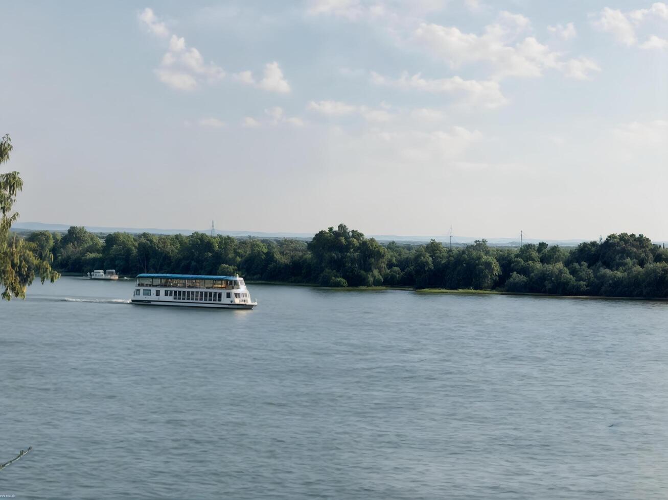 The excursion boat smoothly navigates the expanses of the wide river, leaving behind a light bridge. photo