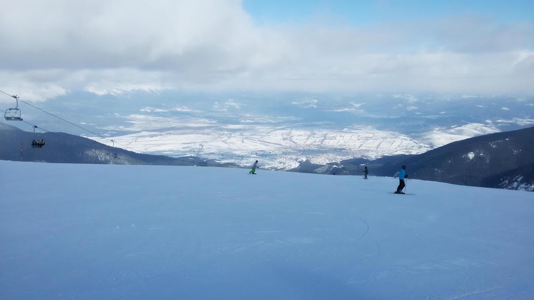 Ski resort. Winter landscape with snow-capped mountains and skiers enjoying the speed and fresh frosty air. photo