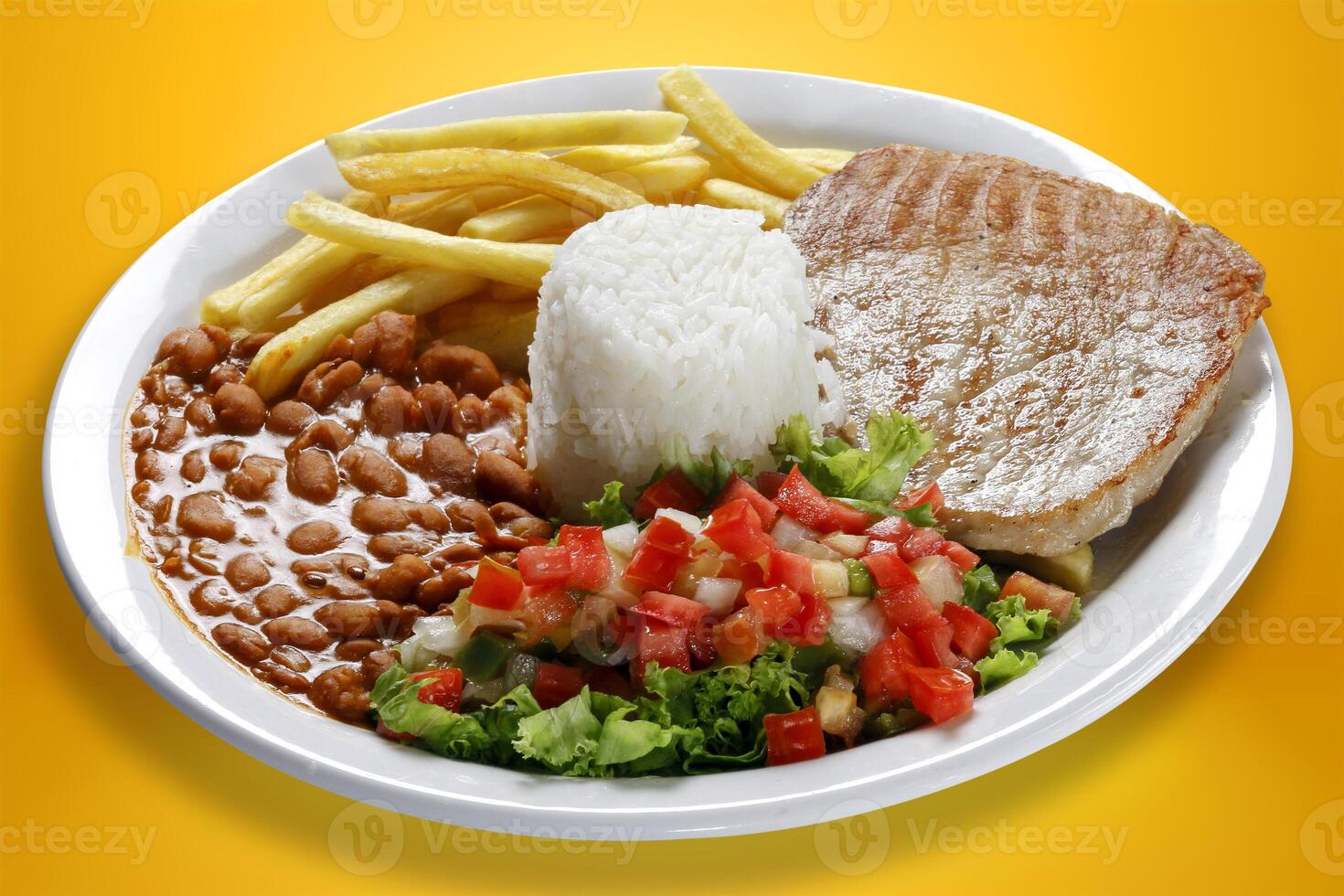 Rice, beans, grilled pork, salad and french fries. photo