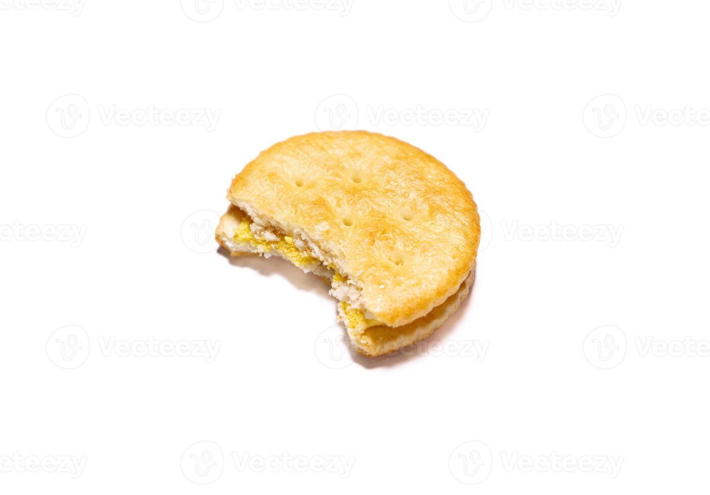 Bitten biscuit with cheese cream filling isolated on white background. photo