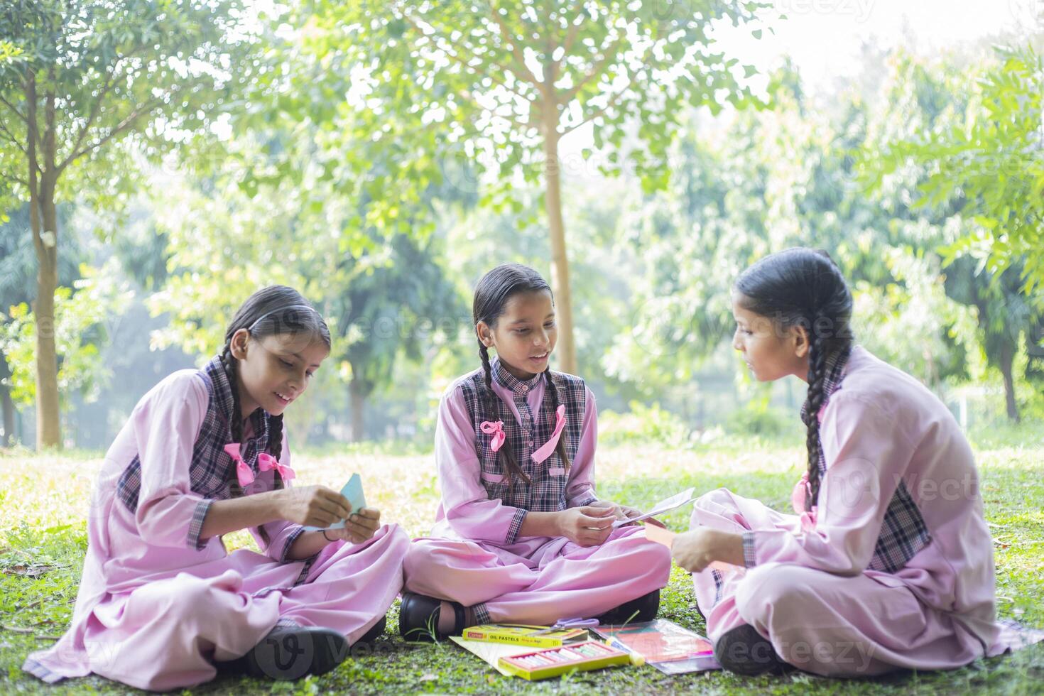 Three Female Students Playing Blindfold Game In The School Park photo