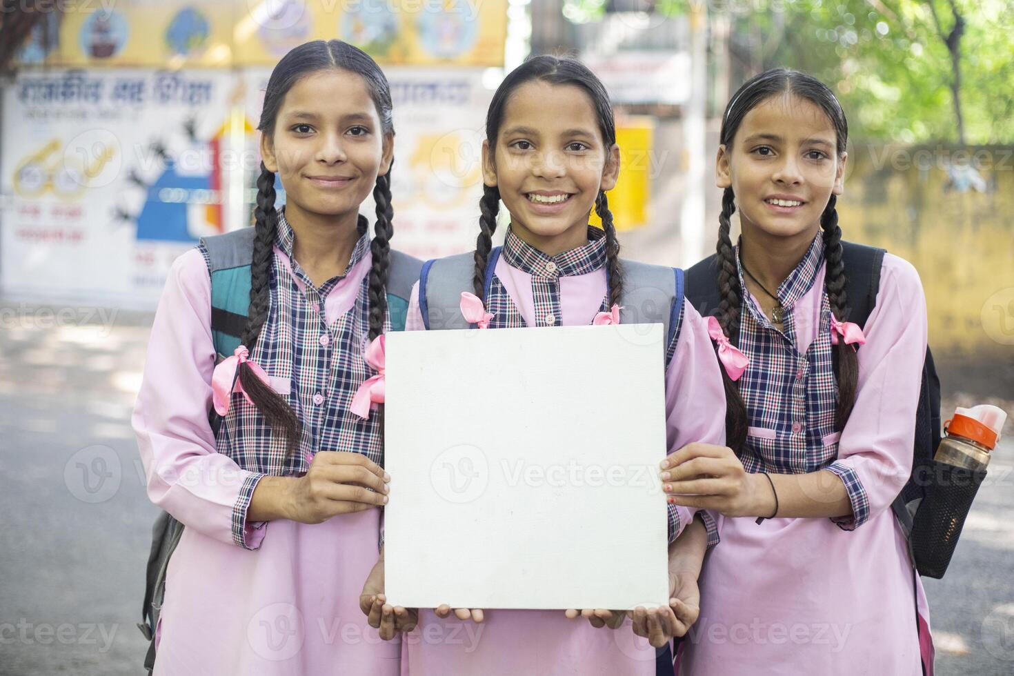 Three Female Class Fellow Are Walking To School And One Is Looking Back photo