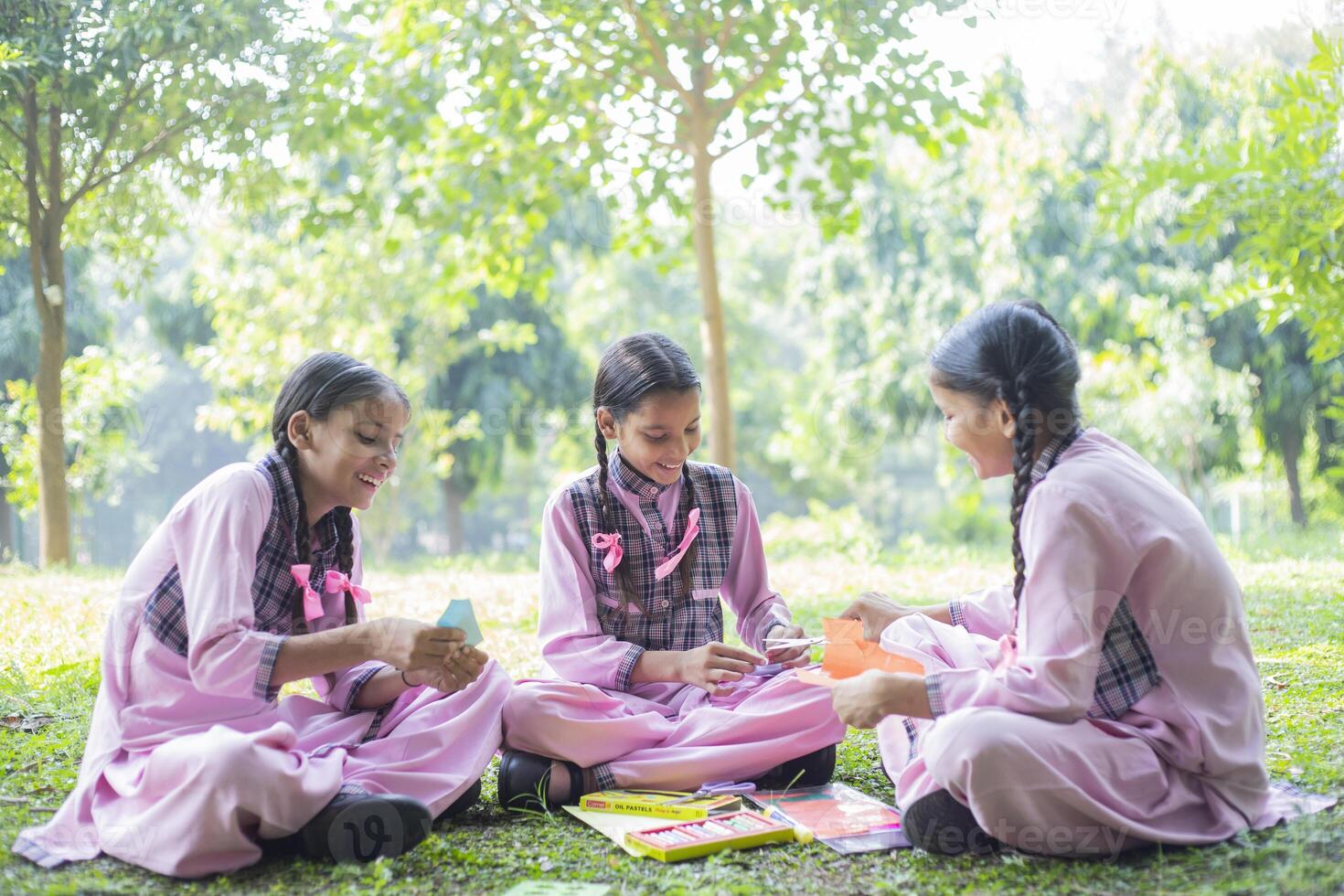 Three Girl Fiends Are Making Caps Through Paper Crafts photo