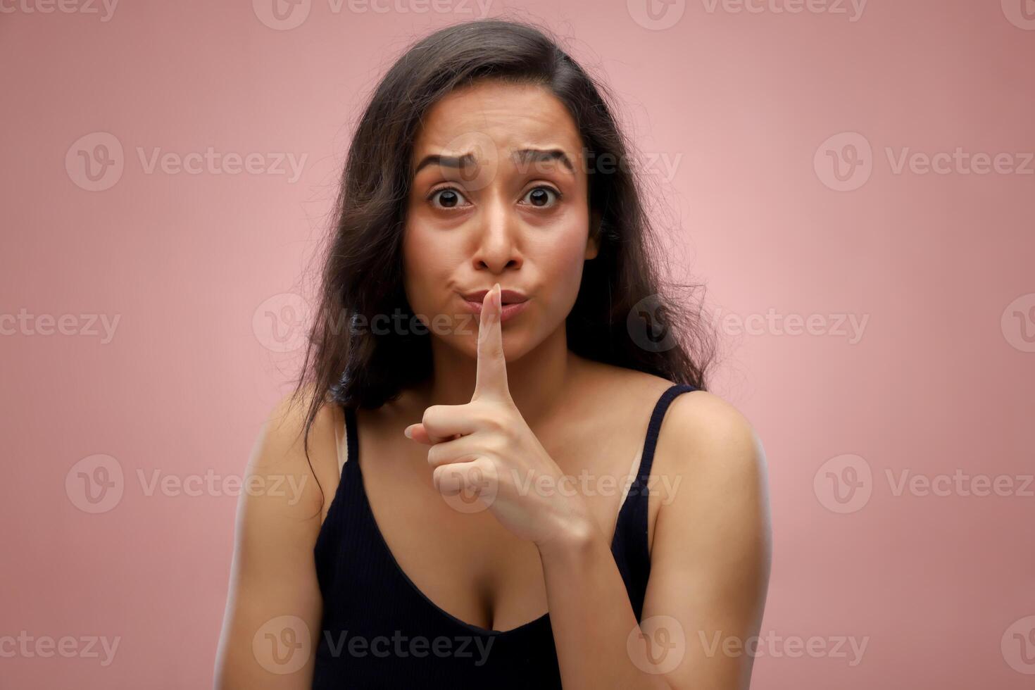 Young Beautiful Woman With Long Hair Putting Her Fingers On Her Mouth photo