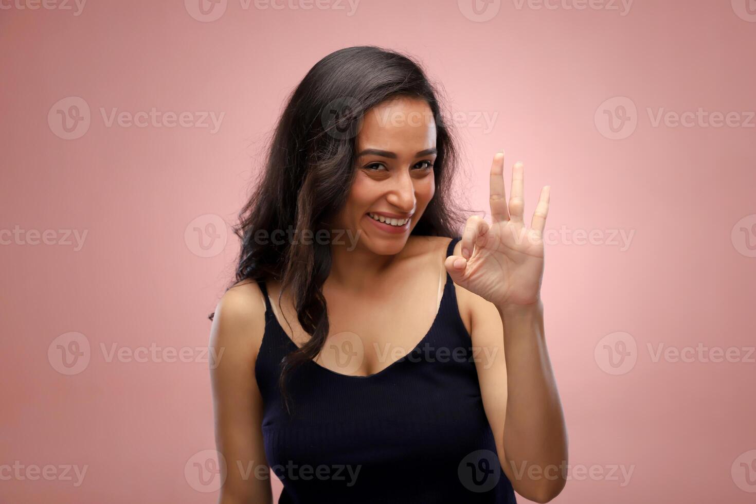 A Lovely Woman Smiling And Showing The Ok Hand Sign Towards The Camera photo