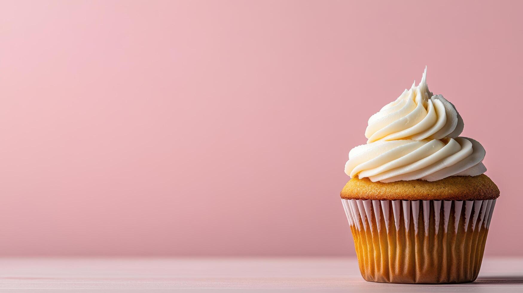 A cupcake with white frosting on a pink background photo