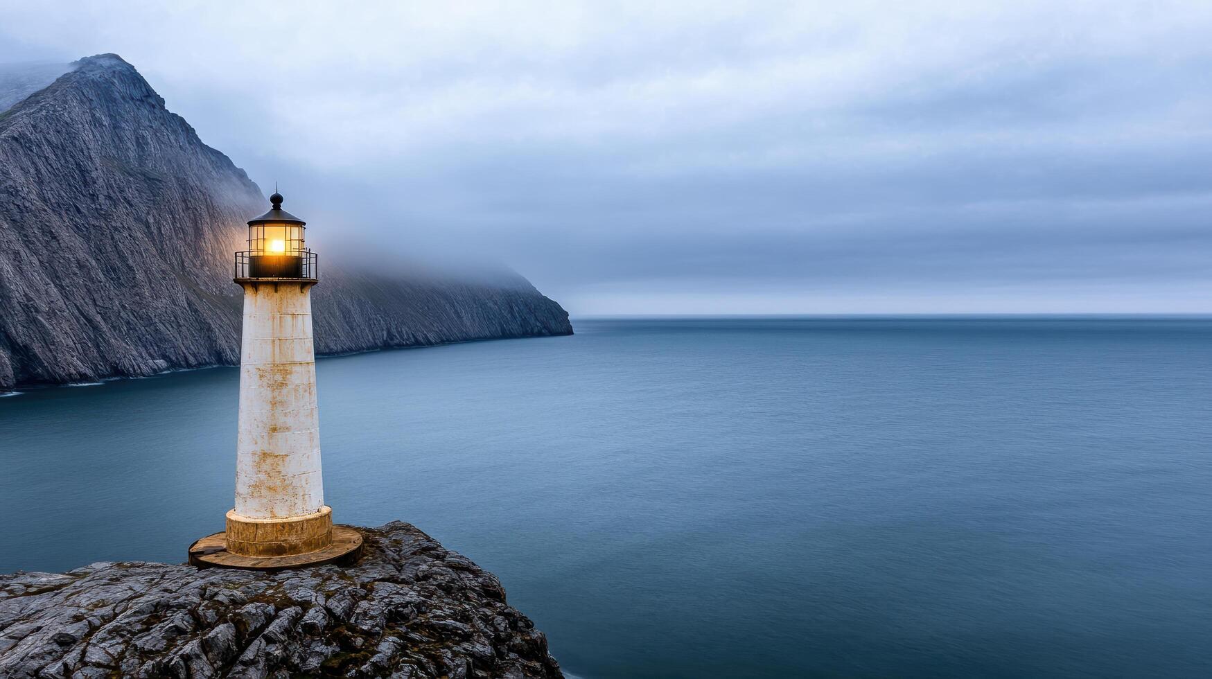 A lighthouse on the edge of a cliff overlooking the ocean photo