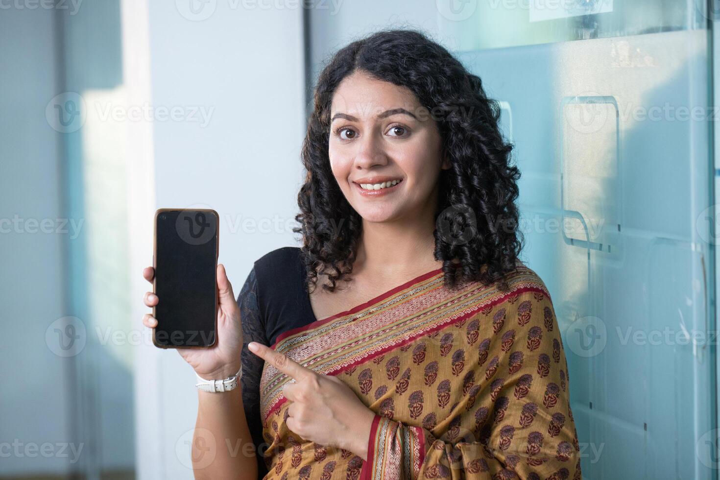 Happy Business Woman Pointing Finger At Mobile Phone photo
