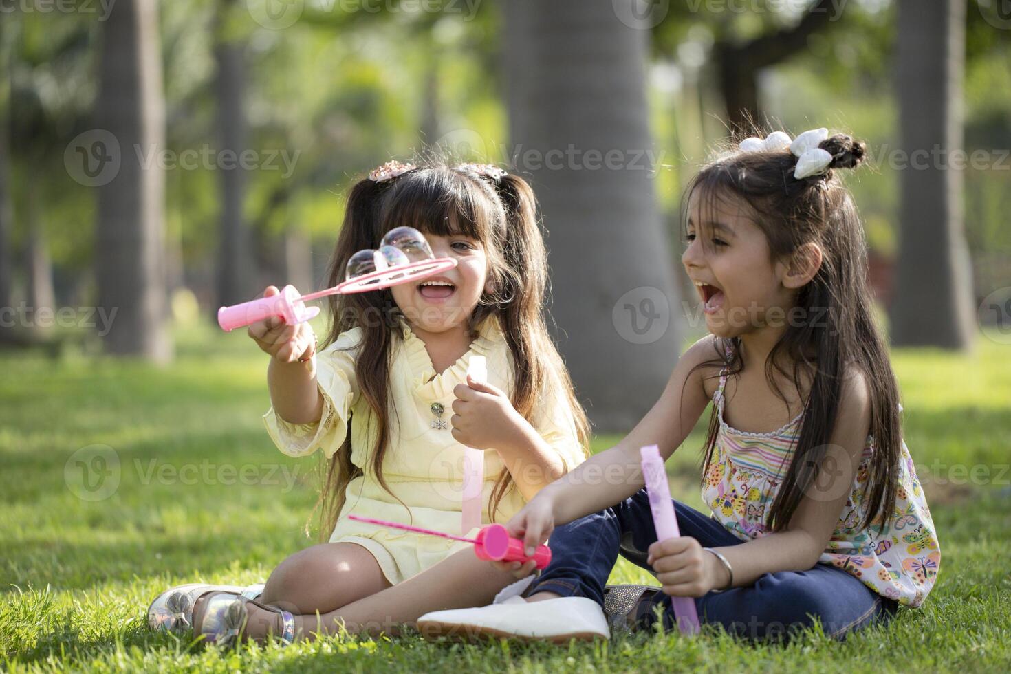 Girls Laughing While Holding Pink Bubble Wand In Their Hand photo