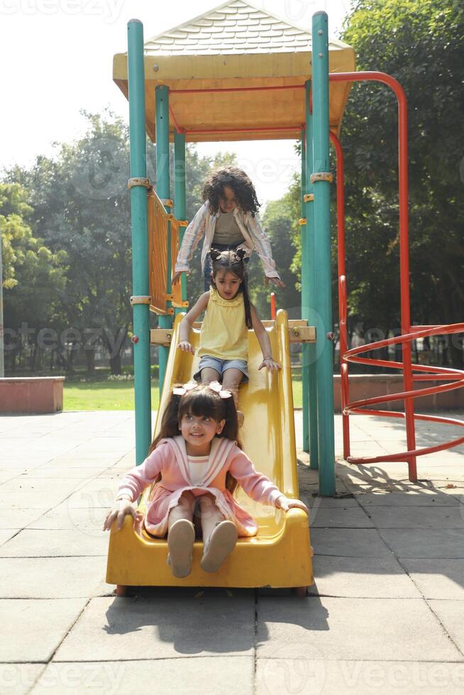 Cutie Pie Kids Playing On Slide In The Park photo