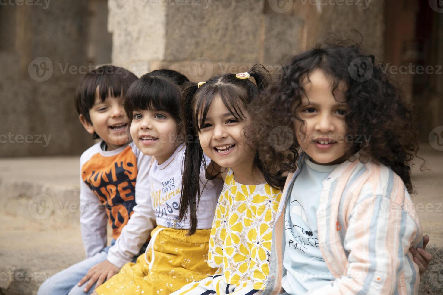 Indian Cute Friends Enjoying While Sitting On Concrete Slab photo
