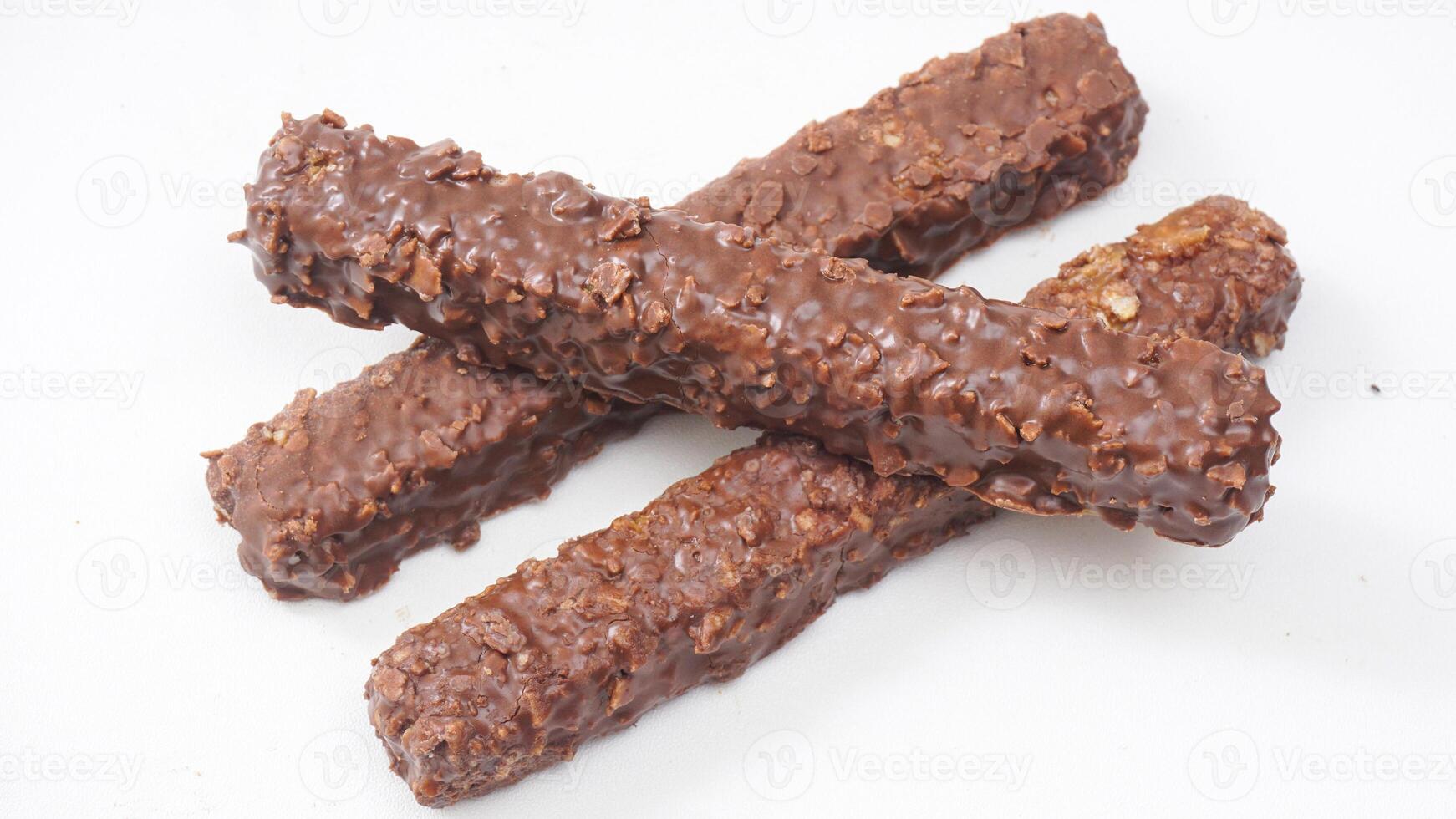 Crunchy chocolate coated wafer bars with caramel and puffed rice crisps isolated on white background photo