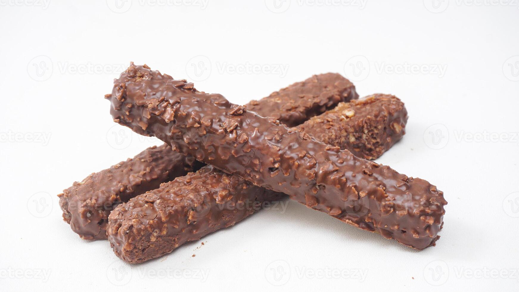 Layered wafer bars with smooth chocolate coating caramel and crisp rice isolated on white background photo