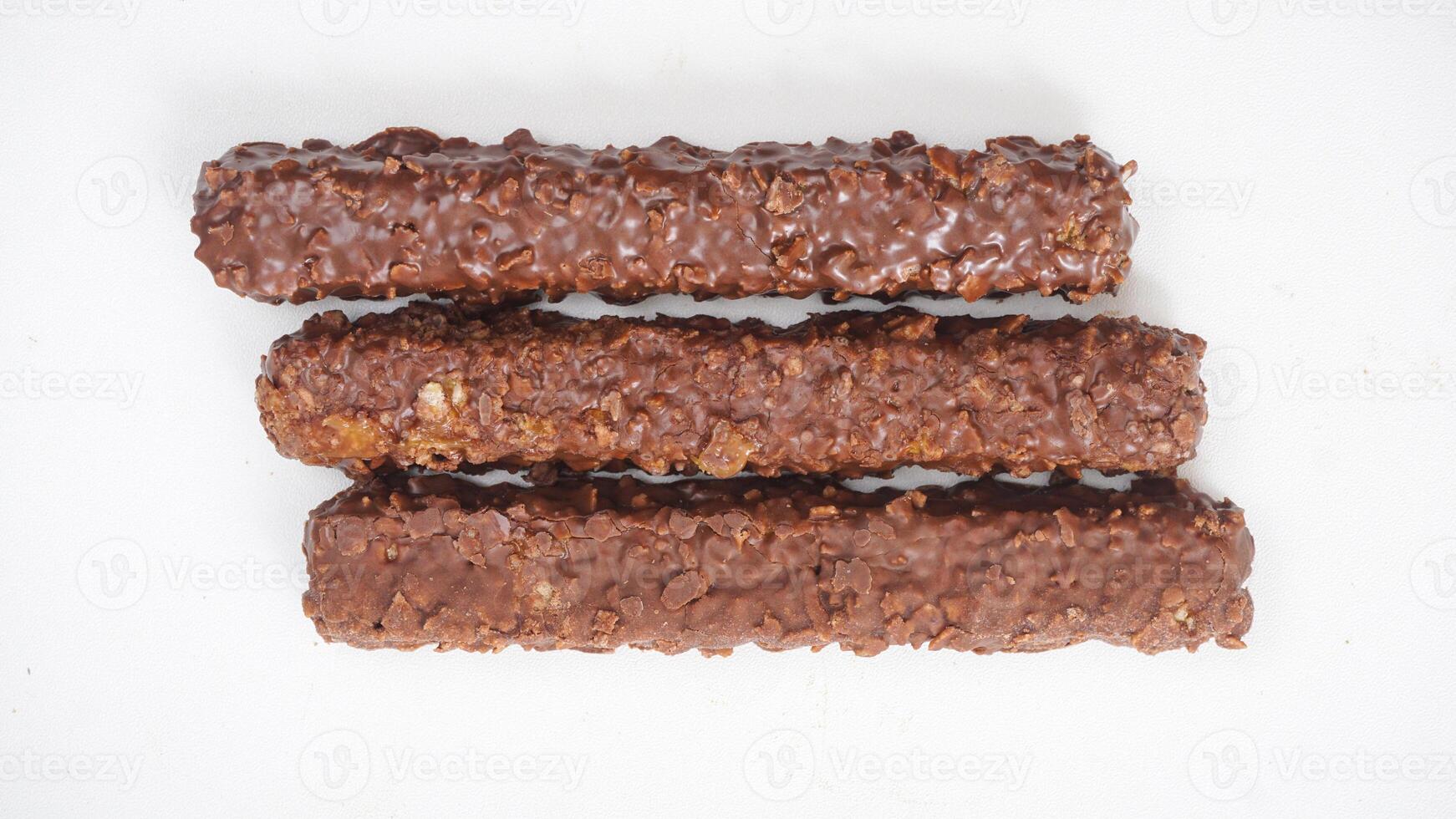 Chocolate coated caramel wafer bars with crunchy layers and puffed rice isolated on white background photo