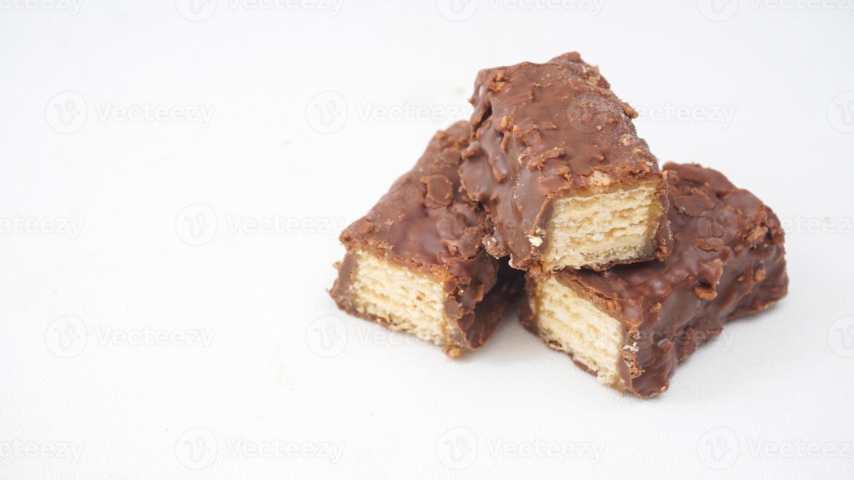 Crispy and sweet chocolate wafer bars with caramel and rice crisps isolated on white background photo
