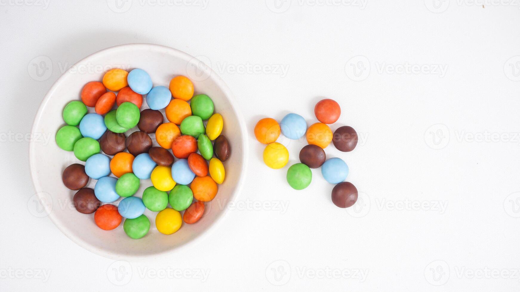 Thin sugar shell chocolate candies with a smooth and rich chocolate filling isolated on white background photo