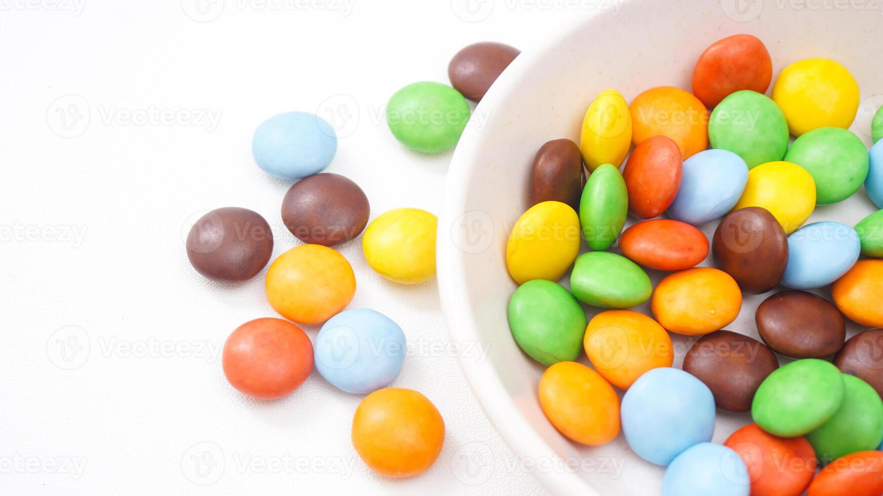 Sugar coated chocolate candies with a vibrant and crunchy texture isolated on white background photo