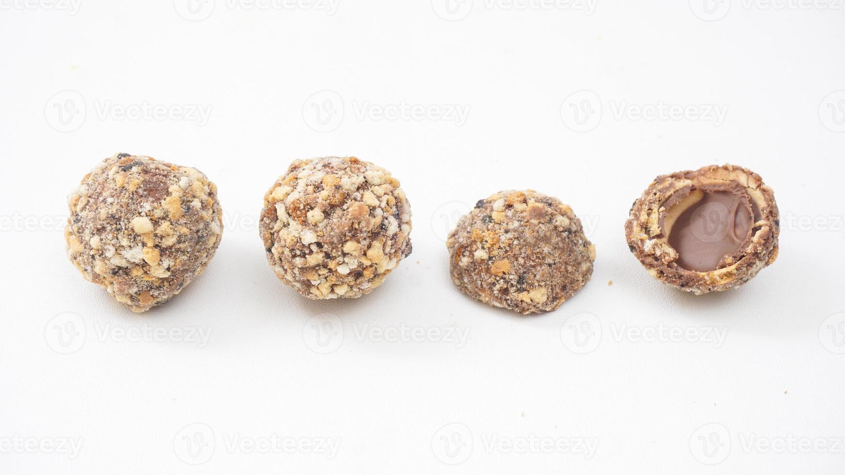 Chocolate truffles covered in finely chopped nuts with a creamy chocolate core isolated on white background photo
