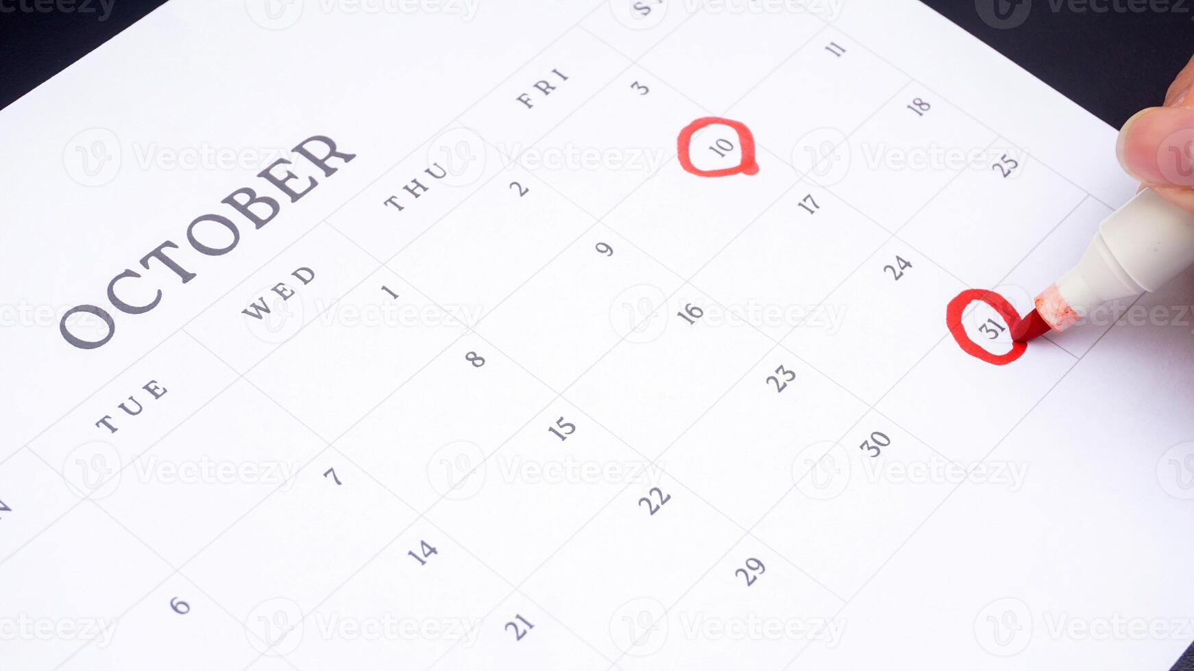 Red circle marked on a calendar at 10 and 31 of October as symbol of important day photo