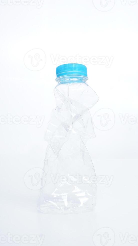 Crumpled used plastic water bottle with light blue bottle cap isolated on white background photo
