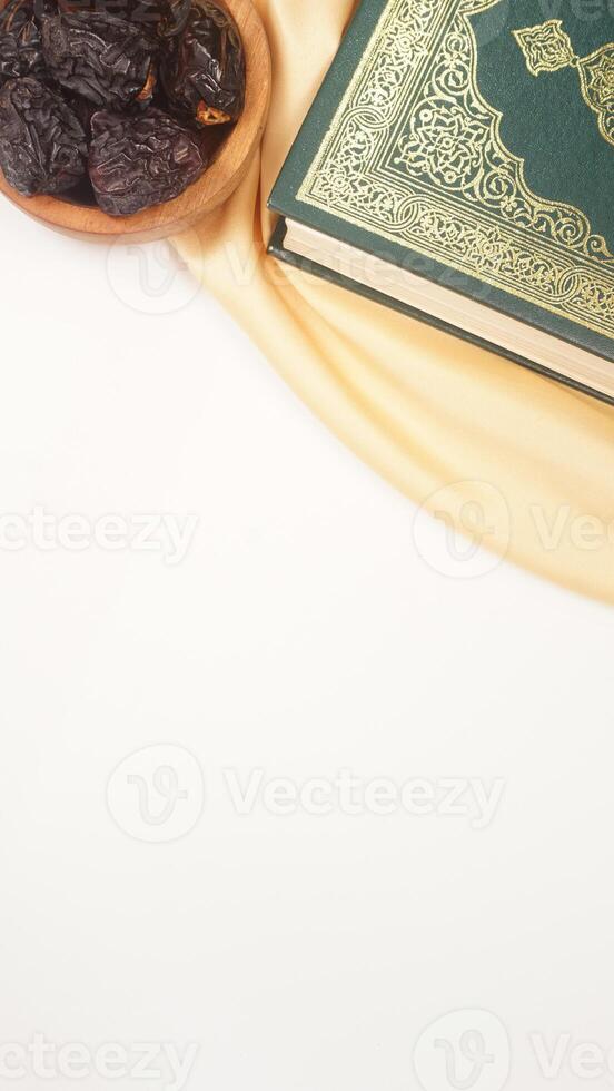 Muslim decoration for Ramadan and Eid al-Fitr with holy Quran, dates fruit, and beige fabric isolated on white background photo