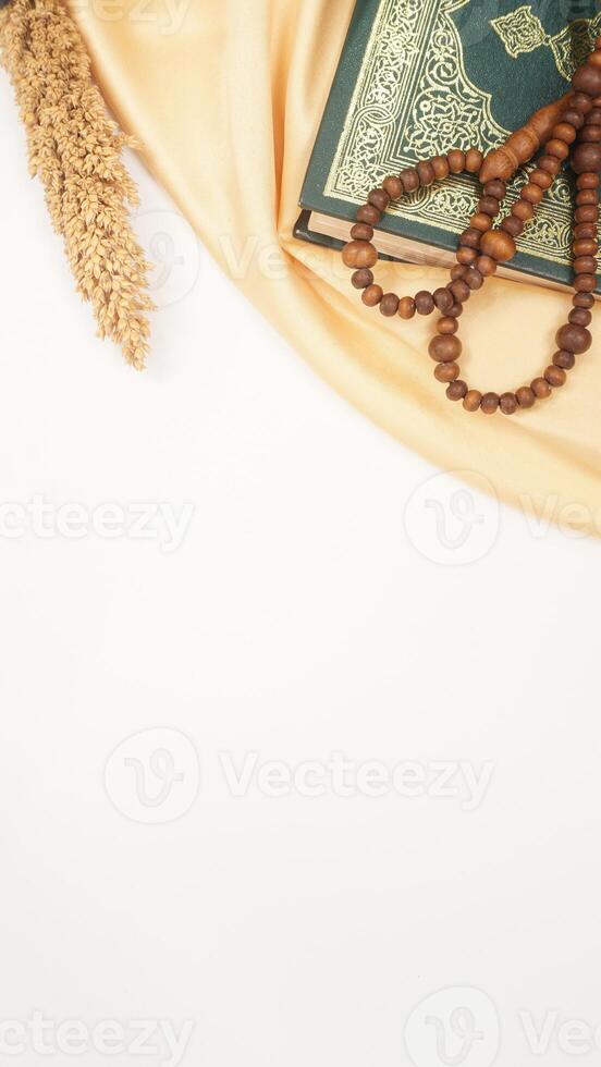 Muslim decoration for Ramadan and Eid al-Fitr with holy Quran, prayer beads, and beige fabric isolated on white background photo