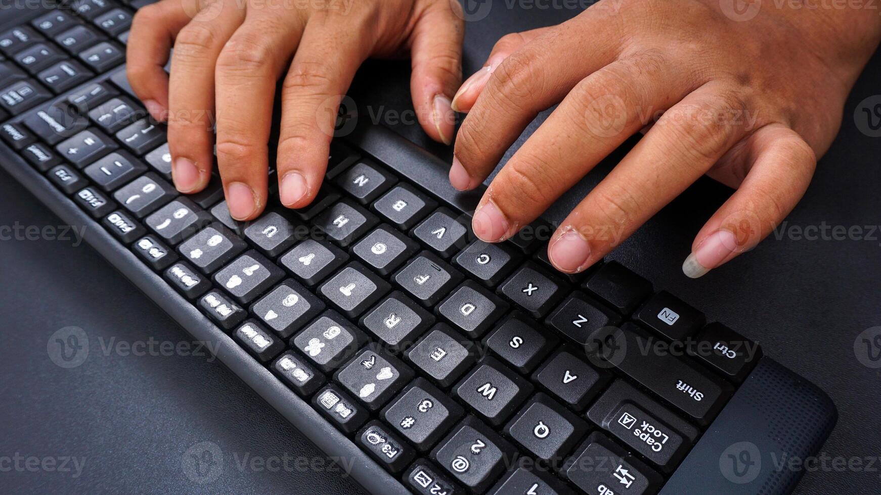Finger texting on keyboard isolated on black background photo