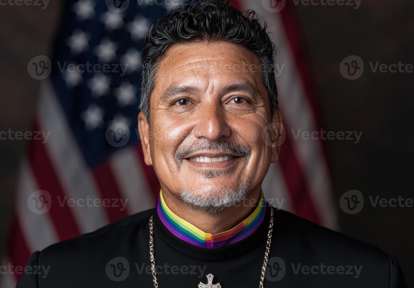 A portrait of a person wearing a rainbow stole in front of an American flag photo