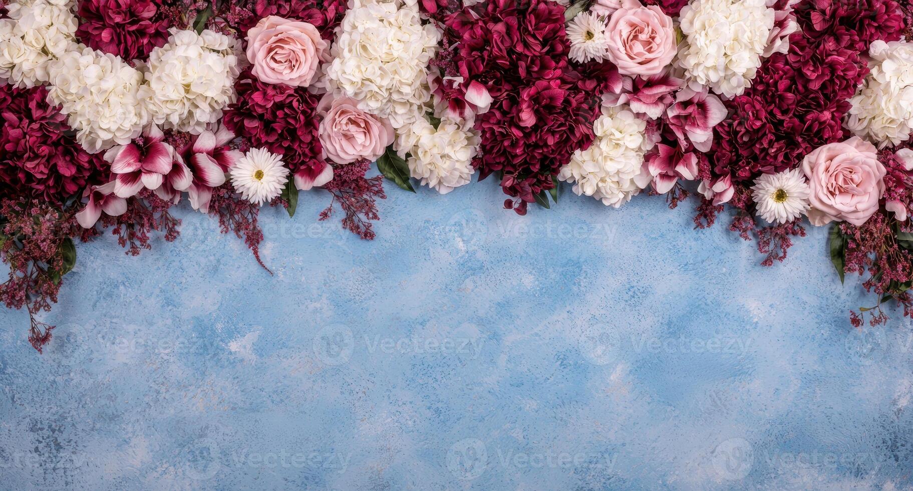 Floral arrangement of roses and hydrangeas on a blue textured background photo
