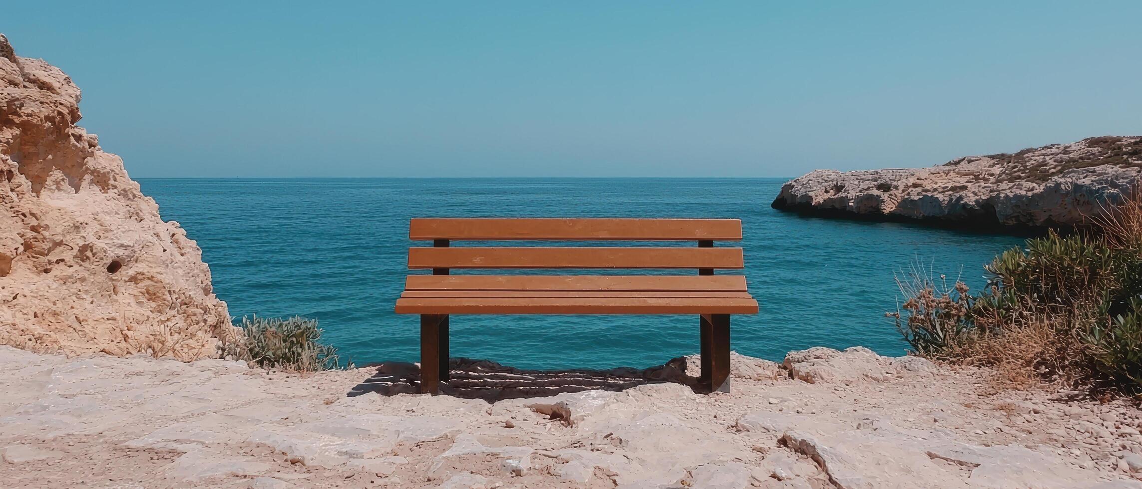 Bench overlooking the ocean on a sunny day. photo