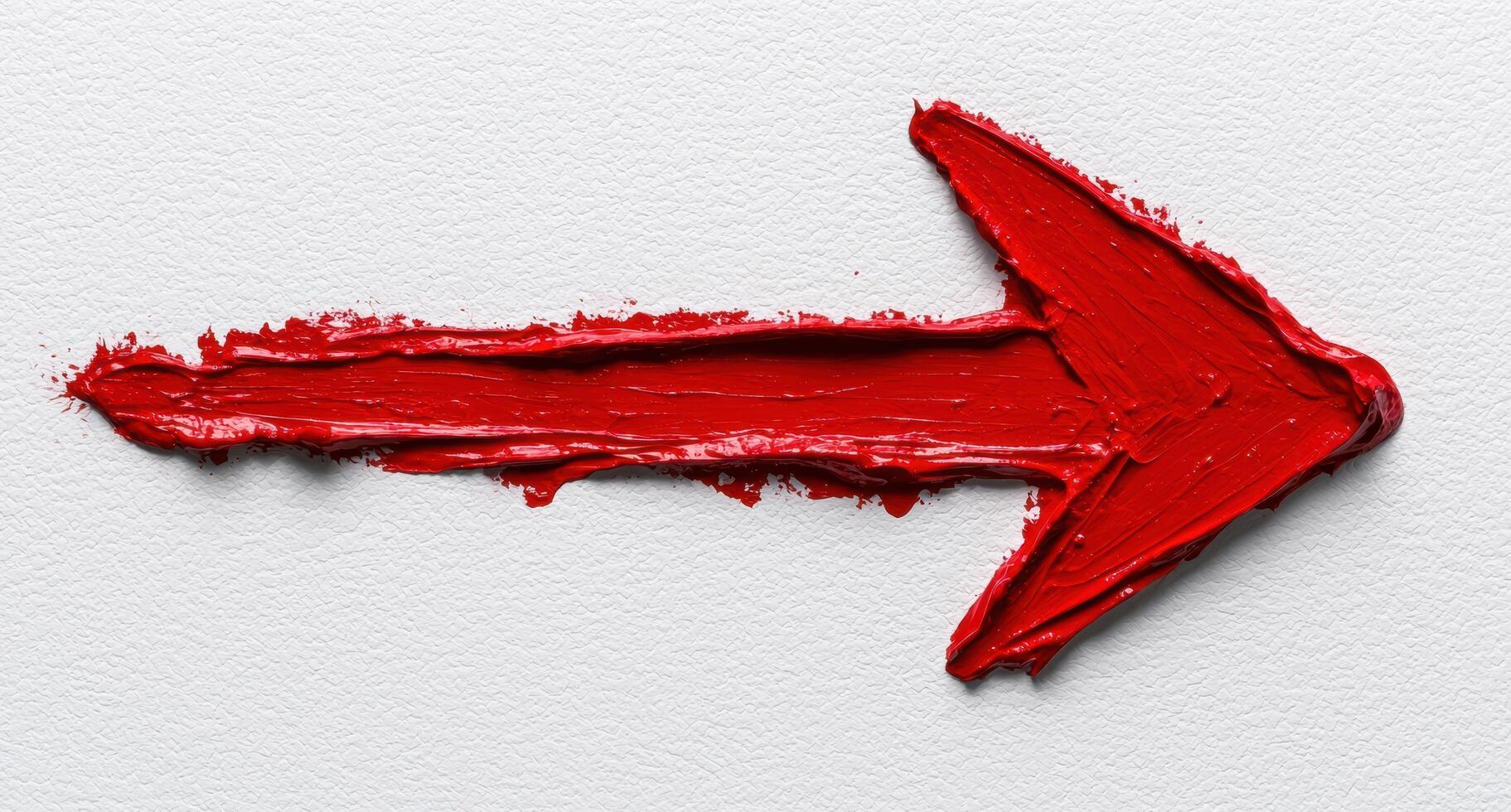 A red painted arrow pointing right on a white background photo