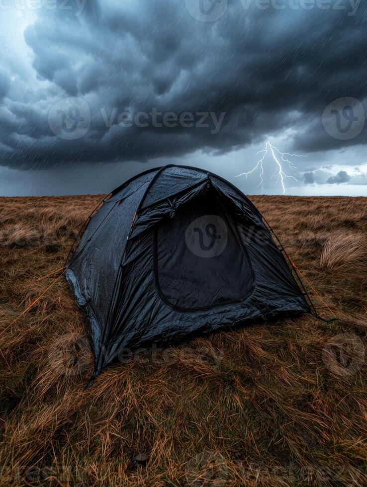A tent stands in a field during a thunderstorm photo
