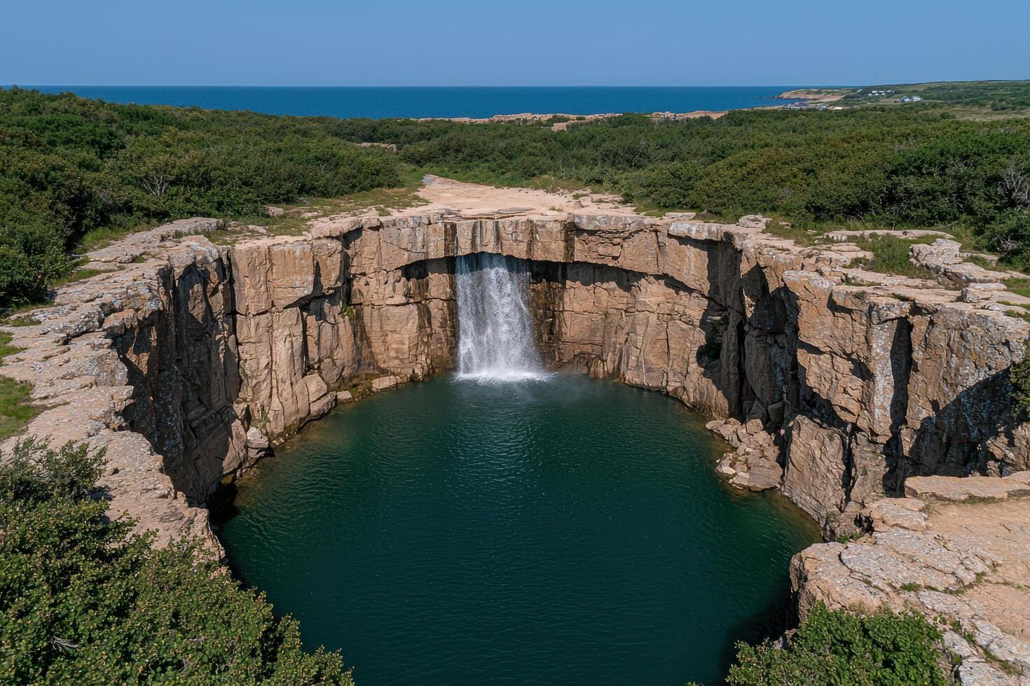 Waterfall cascading into a natural pool surrounded by rocky cliffs photo