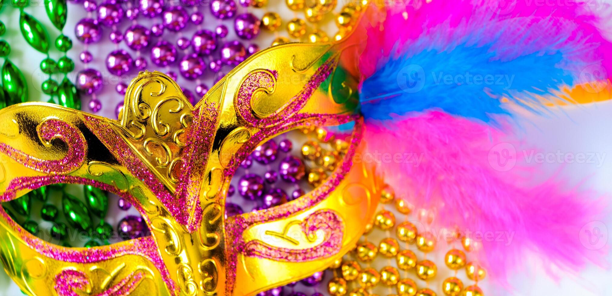 Golden carnival mask and colorful beads close-up. Mardi Gras and Fat Tuesday symbol. photo