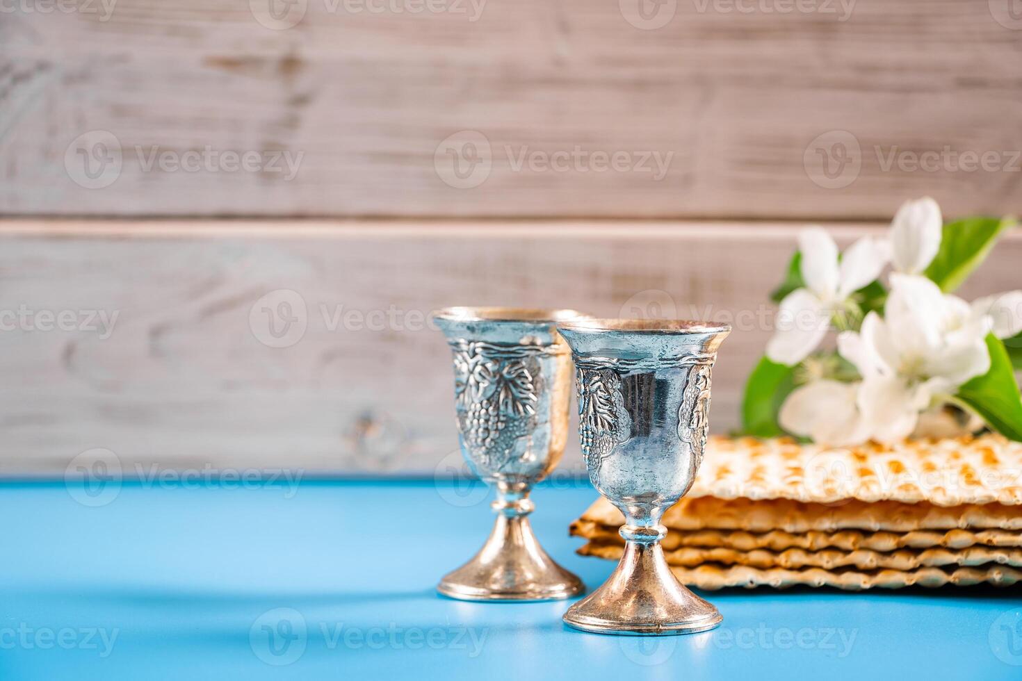 Happy passover. Metal goblet and matzah on blue background photo