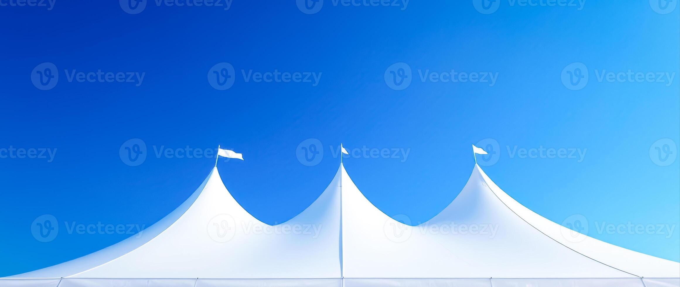 three white party tents set against a vibrant blue sky photo