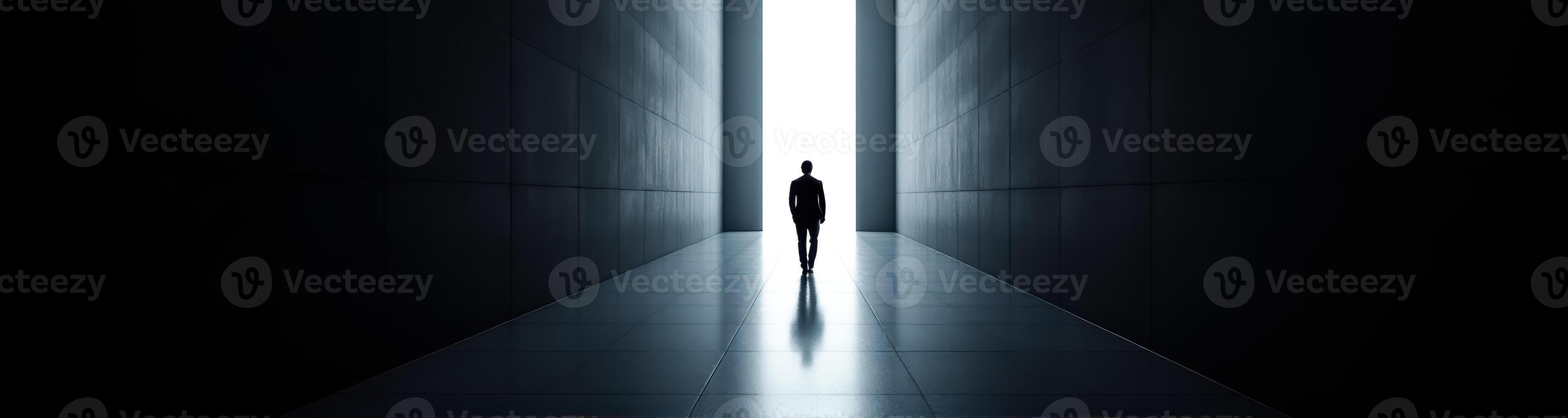 person in formal wear walks towards a bright light at the end of a dark corridor photo