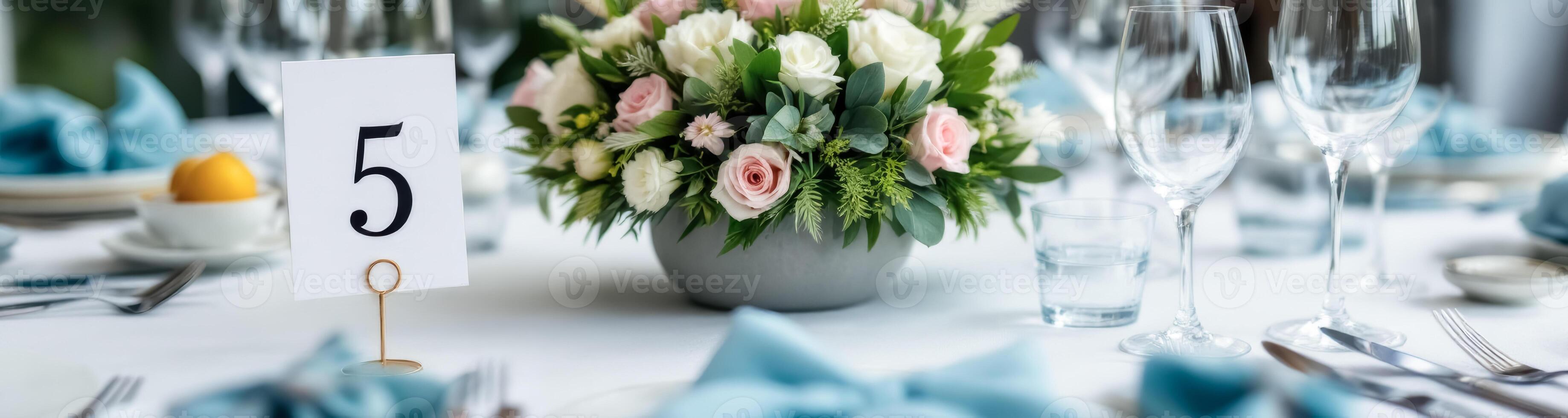 elegant table setting with pastel-colored flower centerpiece and table number five photo