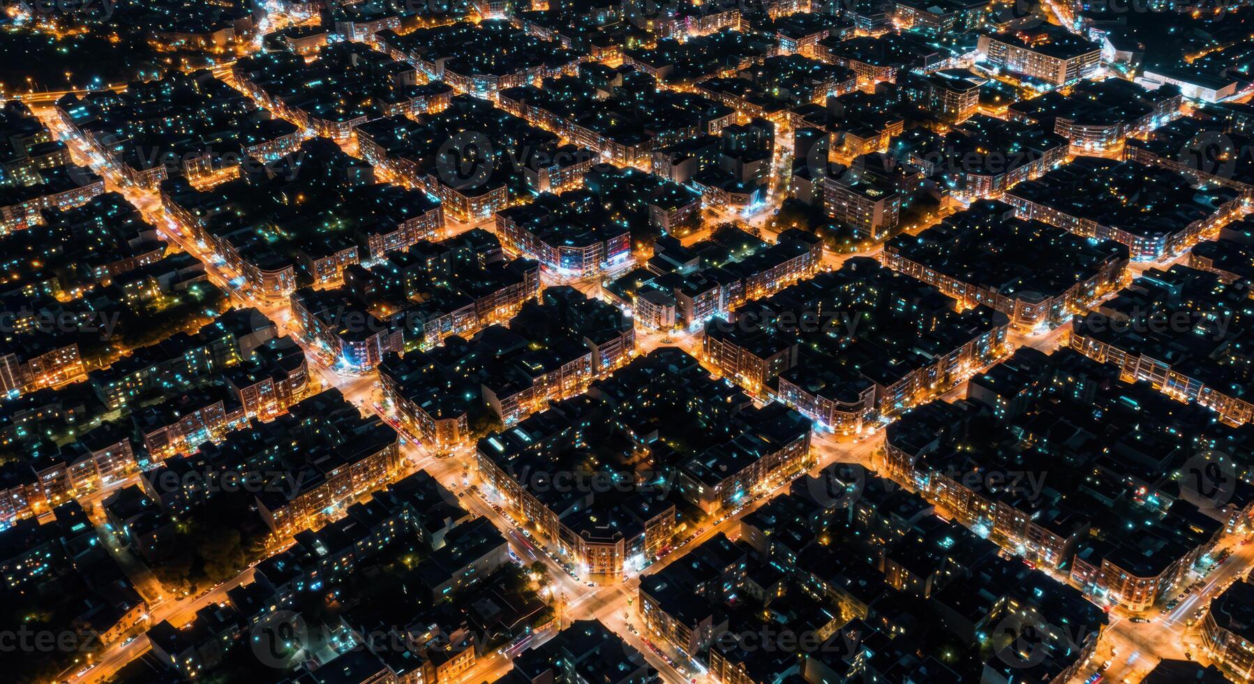 An aerial view of a dense urban landscape illuminated at night with warm city lights. photo