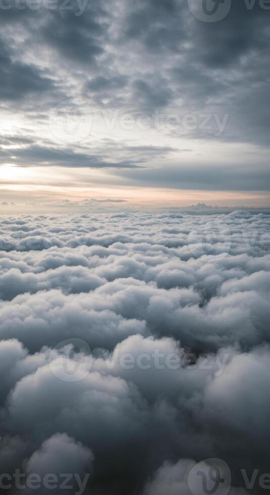 Gently rolling white clouds stretch to the horizon under a pastel sunset sky. photo