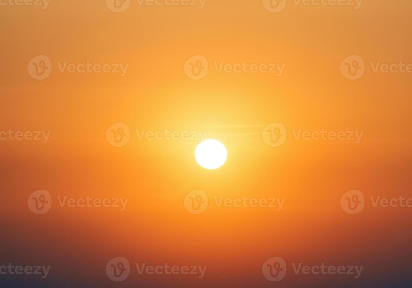 A brilliant sun casts a warm glow on the orange sky, creating a beautiful gradient. photo