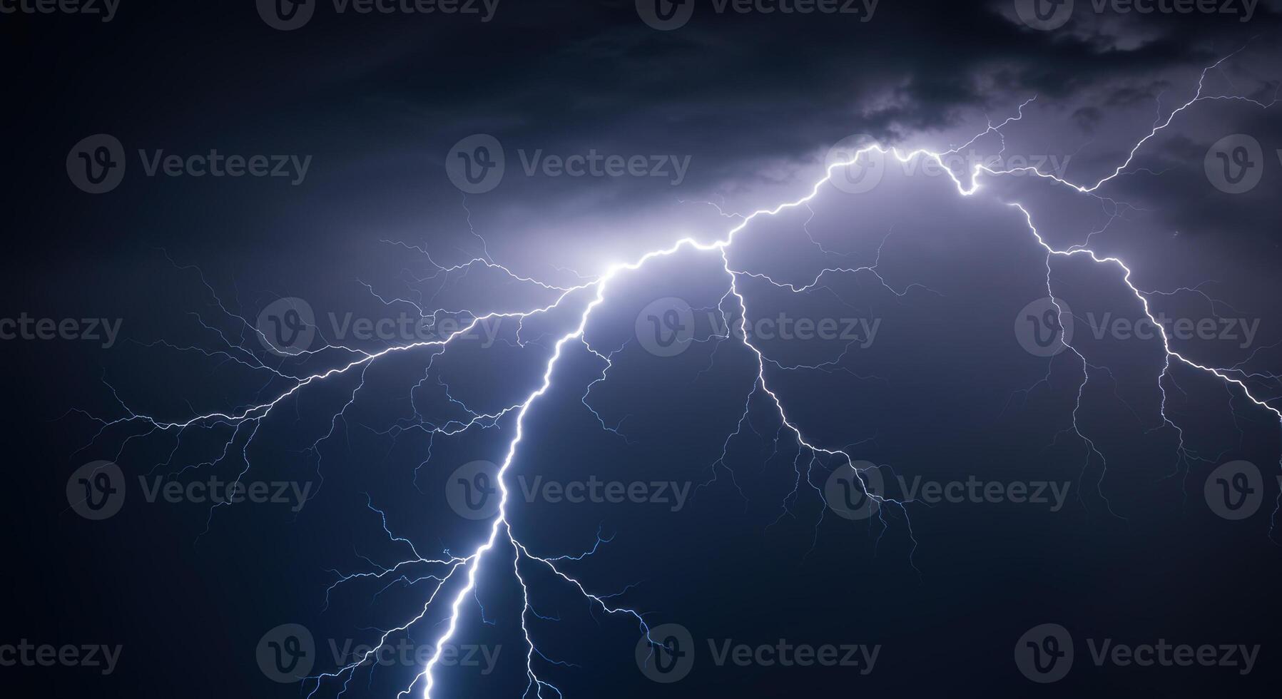 A powerful display of lightning illuminates the night sky during a thunderstorm. photo