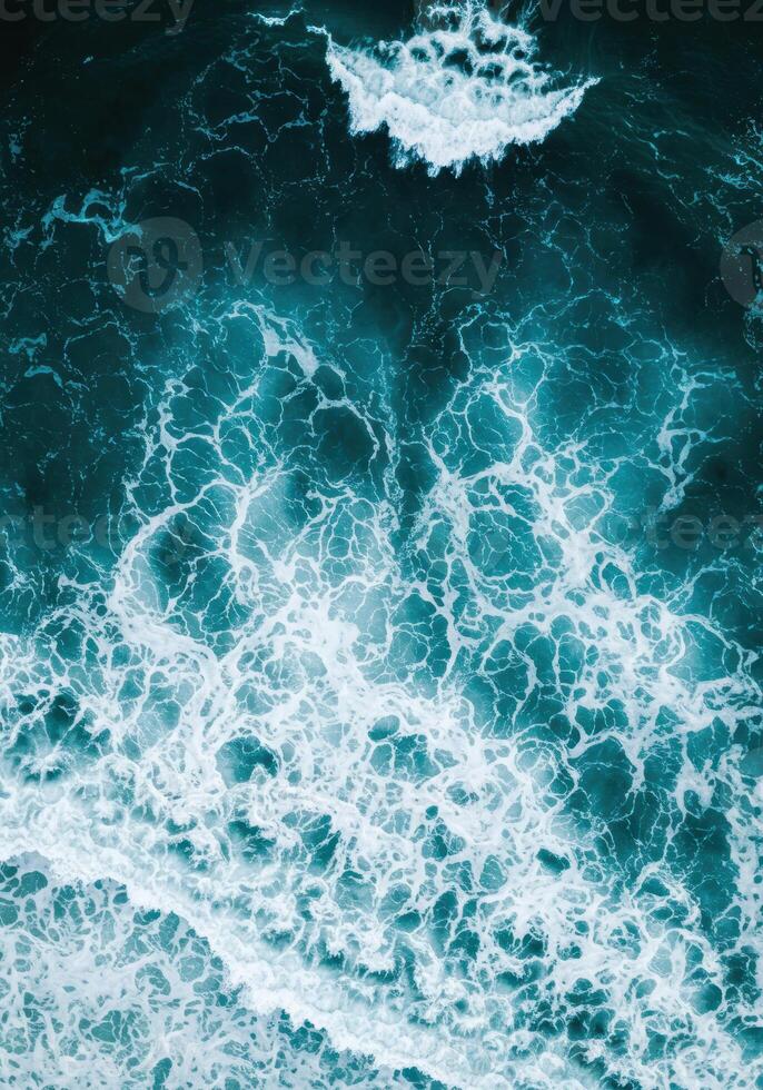 An aerial view showcases the intricate foam patterns of ocean waves in vivid detail. photo