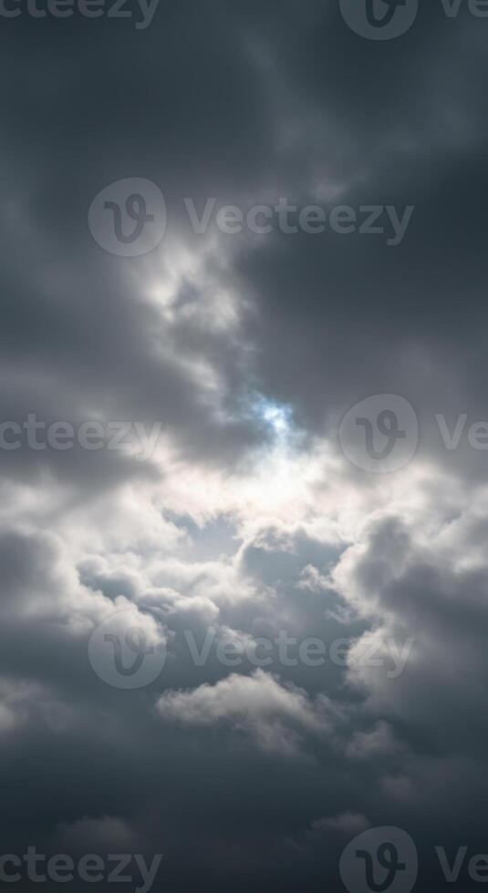 Moody storm clouds fill the sky, with a small patch of blue peeking through. photo
