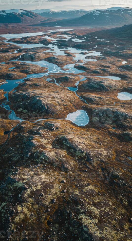 An awe inspiring aerial shot showcasing a vast, rugged landscape filled with water, rocks and low vegetation. photo