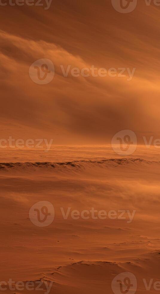 An expansive vista of a windswept, desert landscape under a dramatic, clouded sky. photo