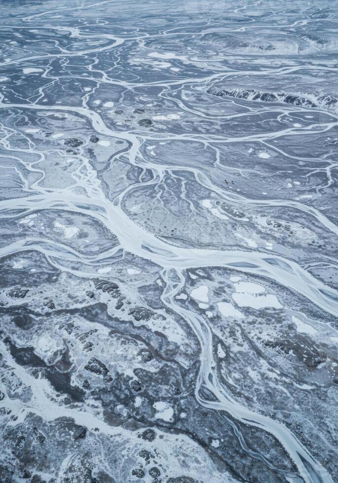 Intricate waterways carve through a snow-covered landscape, creating stunning natural patterns. photo