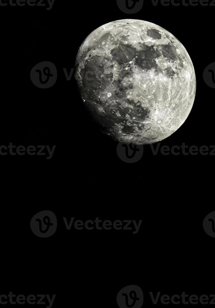 The moon, a captivating beacon, shines brightly in the vast expanse of the dark night sky. photo