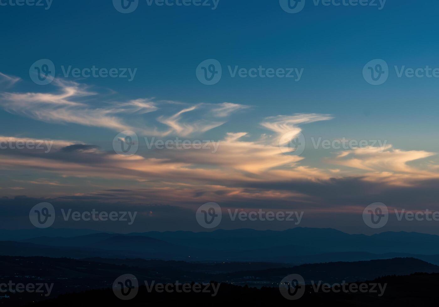 A breathtaking view of a mountain landscape at sunset, with colorful clouds in the sky. photo