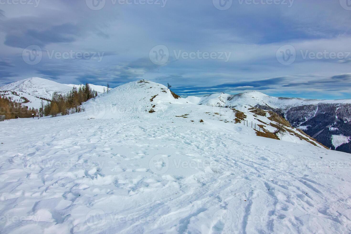 Snow covered mountains under cloudy sky photo